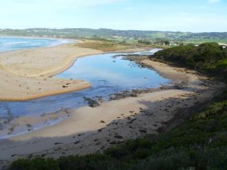 The lower level of the estuary with sand washed out and rocks exposed
