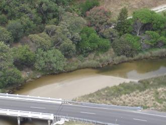 Zoom shot from lower lookout showing sandbar upstream of bridge